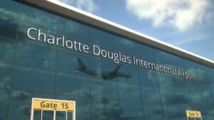 Charlotte Douglas International Airport terminal with a plane in the reflection of the glass