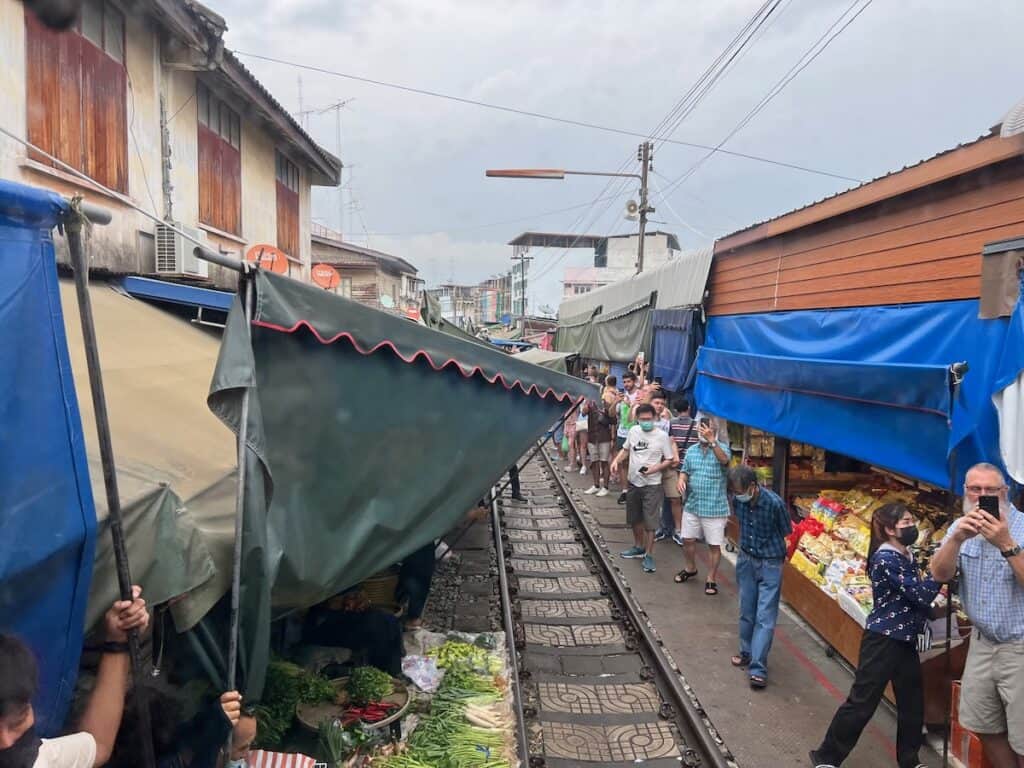 Vendors lowing awnings at the Train market