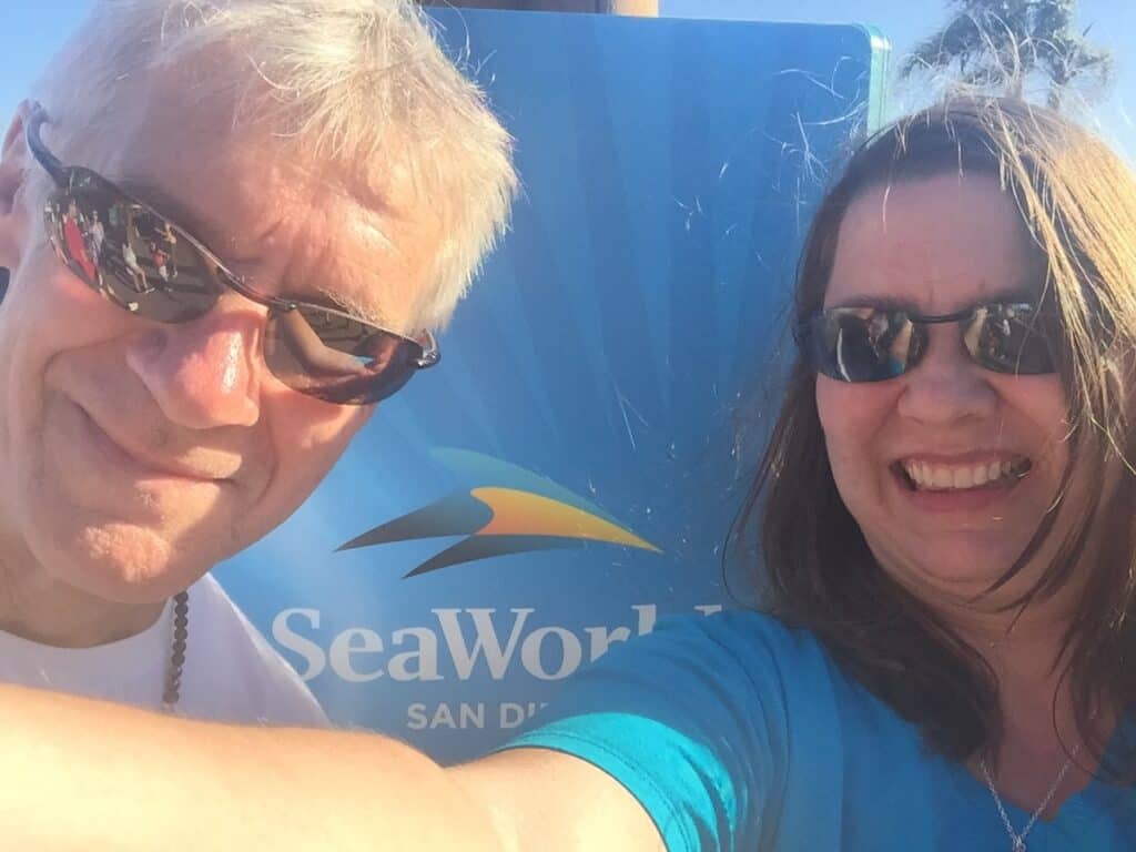 My husband and I in front of the SeaWorld San Diego Sign