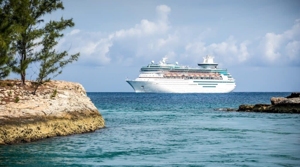 Large cruise ship ancored on the water near a tropical port