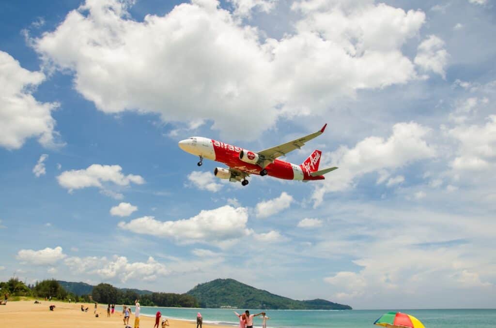 Air Asia airplane landing at Phuket International airport, runway near the beach, Phuket, Thailand.