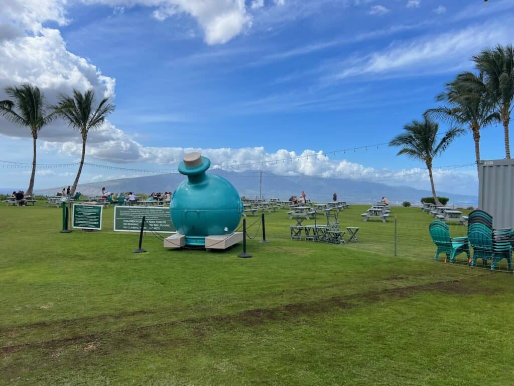 The grounds at Ocean Vodka Organic farms and distillery. A giant ocean vodka bottle stands in the opening with picnic tables overlooking the ocean