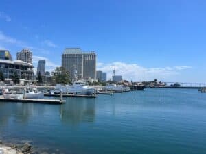 San Diego Harbor skyline view from the water with boats docked and Hyatt and Coronado Bridge in the background