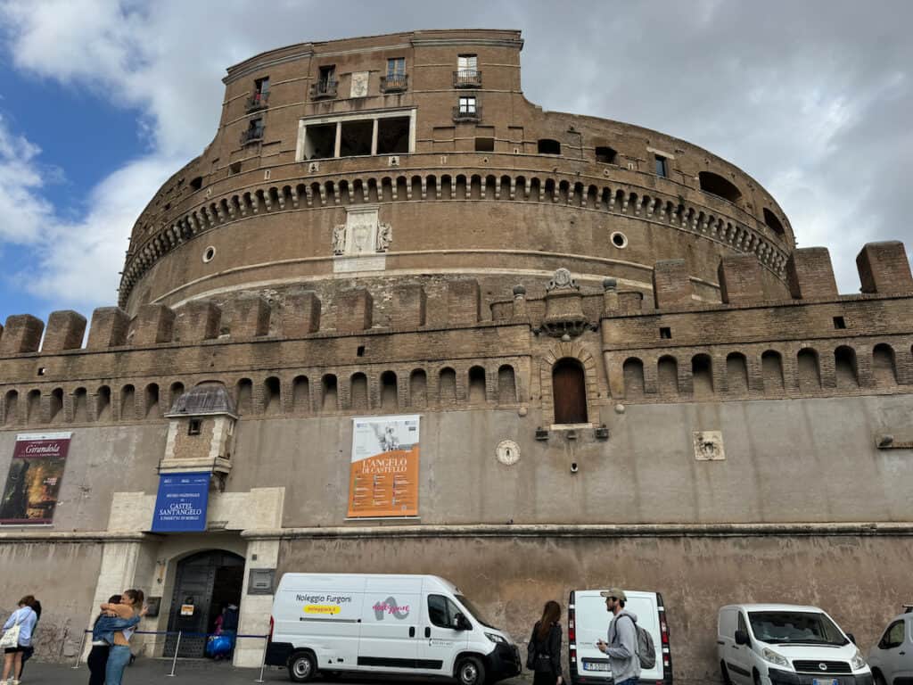 Castel Sant'Angelo in Rome Italy with some cars and people in front of it