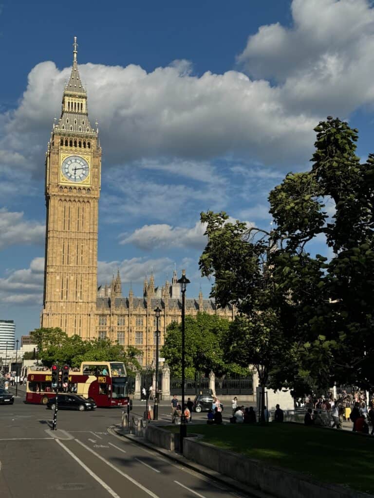 Big Ben with a hop on hop off bus in front of it.