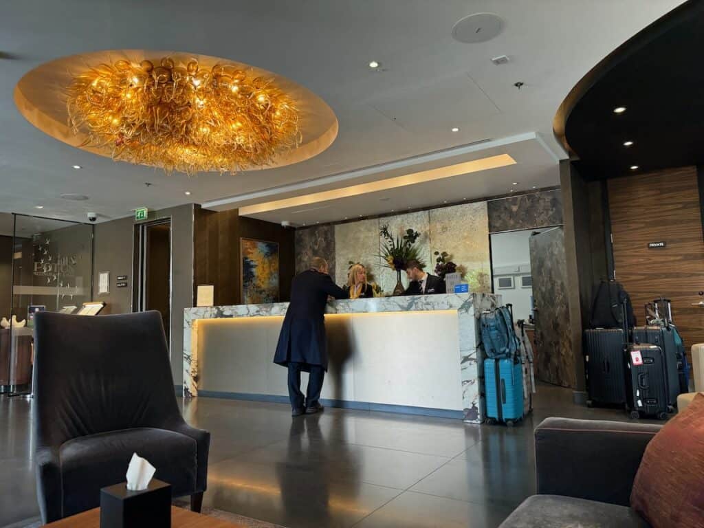 Front desk clerks and man at Hyatt Regency London Albert Embankment Hotel lobby