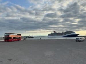 Hop on Hop off bus and a cruise ship in the port of Katakalon near Olympia Greece