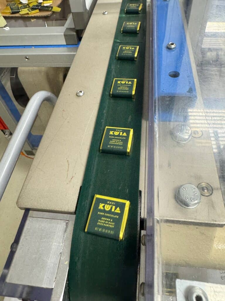 Chocolate bars coming off of the packaging line at Kuia Estate Maui Chocolate Factory