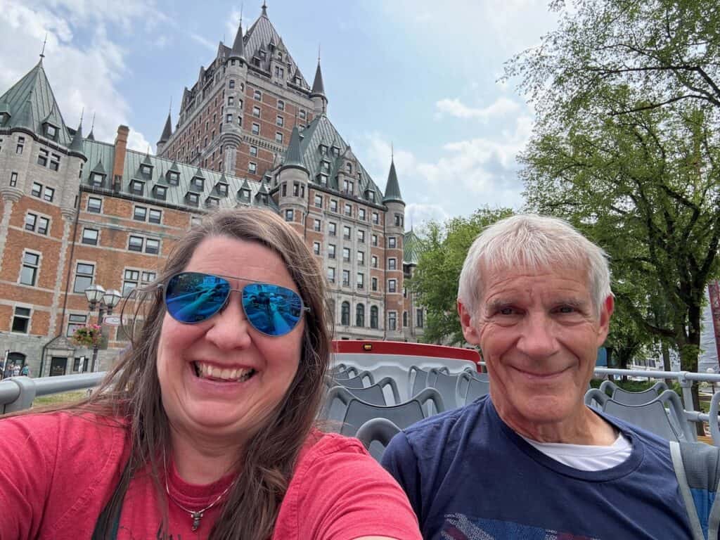 My husband and I on the top deck of the hop on hop off bus with Chateau Frontenac in the background
