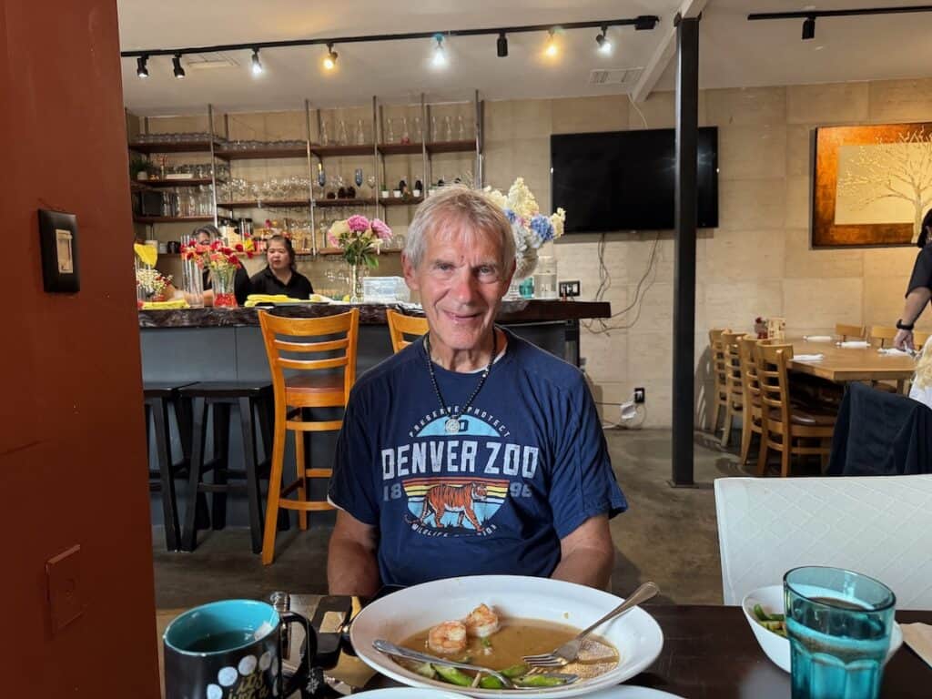 My husband sitting instide at Turmeric Thai Garden La Jolla with the bar in the background