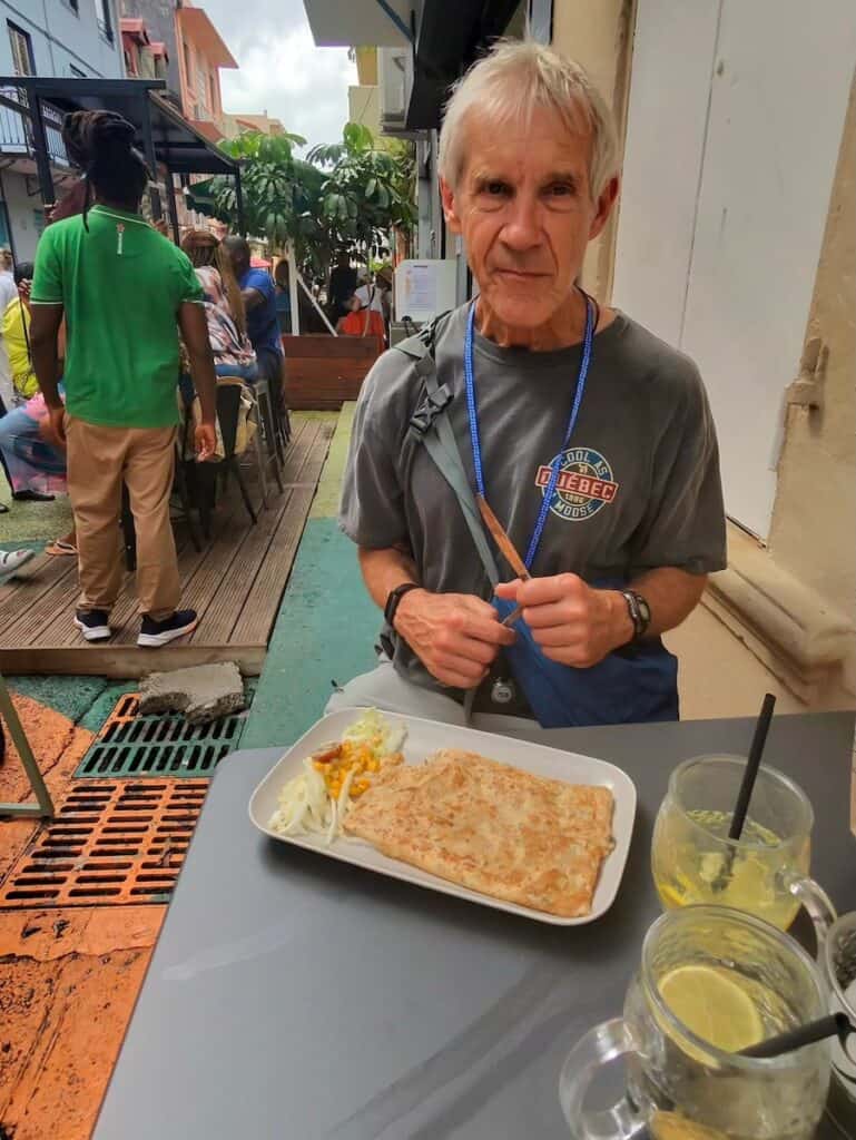 My husband eating his crepe at an outside cafe in Martinique