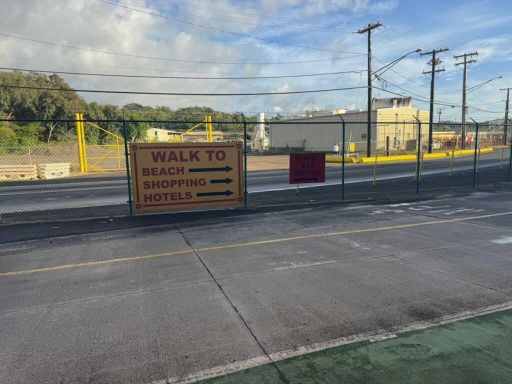Signs right outside the Kauai Port Terminal Building pointing the way to Airport Car Rental Shuttle