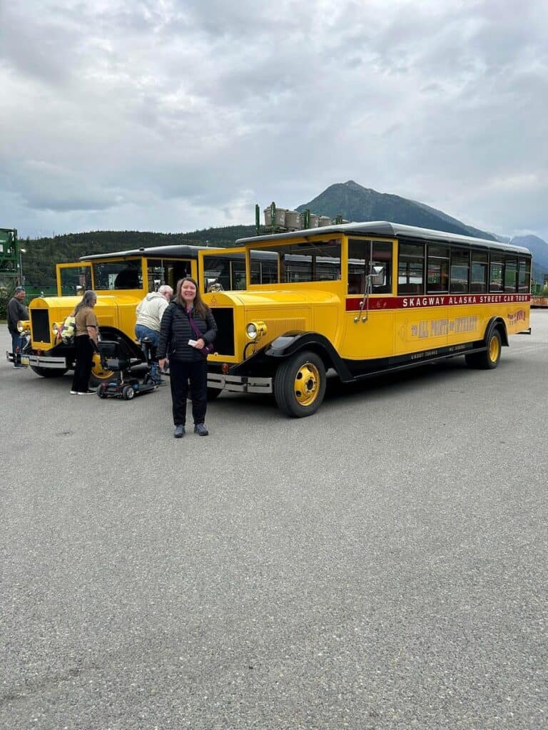 Me in front of the Yellow cars on a cruise stop in Skayway Alaska