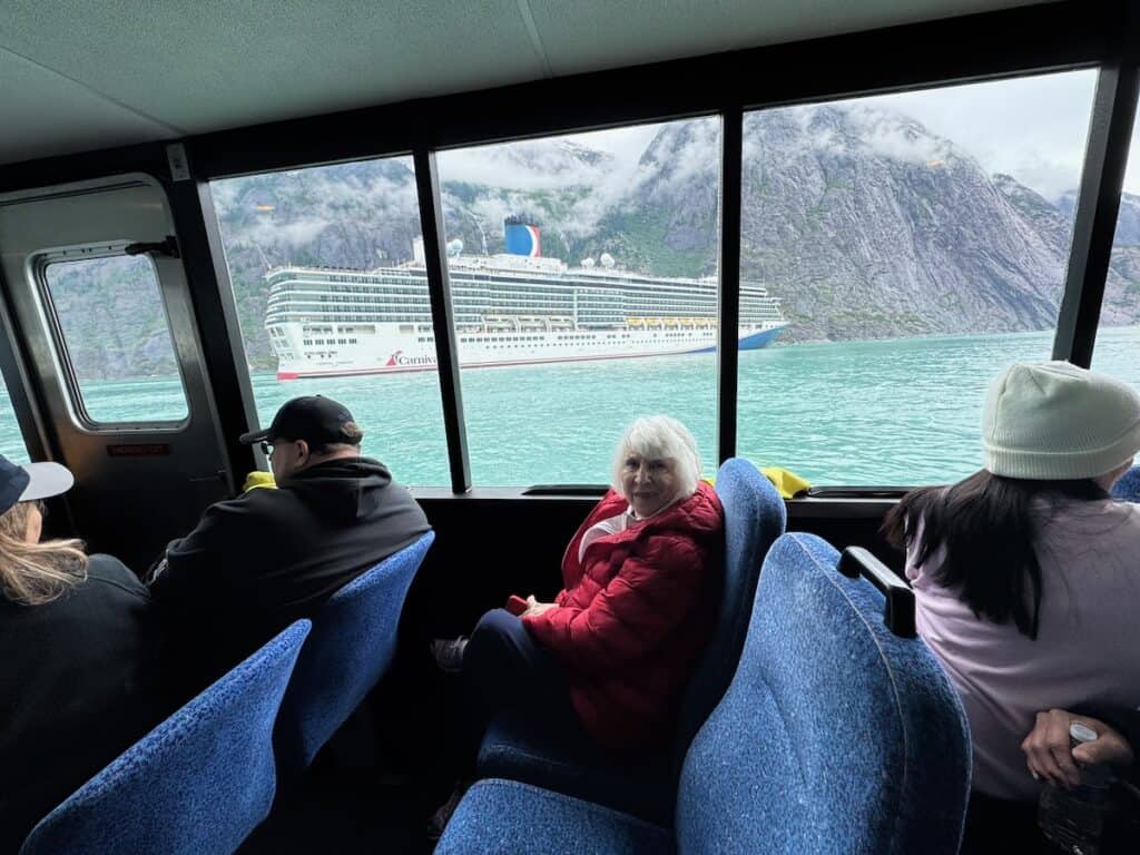 My Mom on a tour from an Alaska cruise with a carnival cruise ship in the background